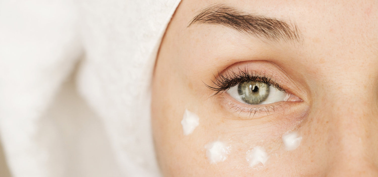 Augencreme getupft unter dem Auge.