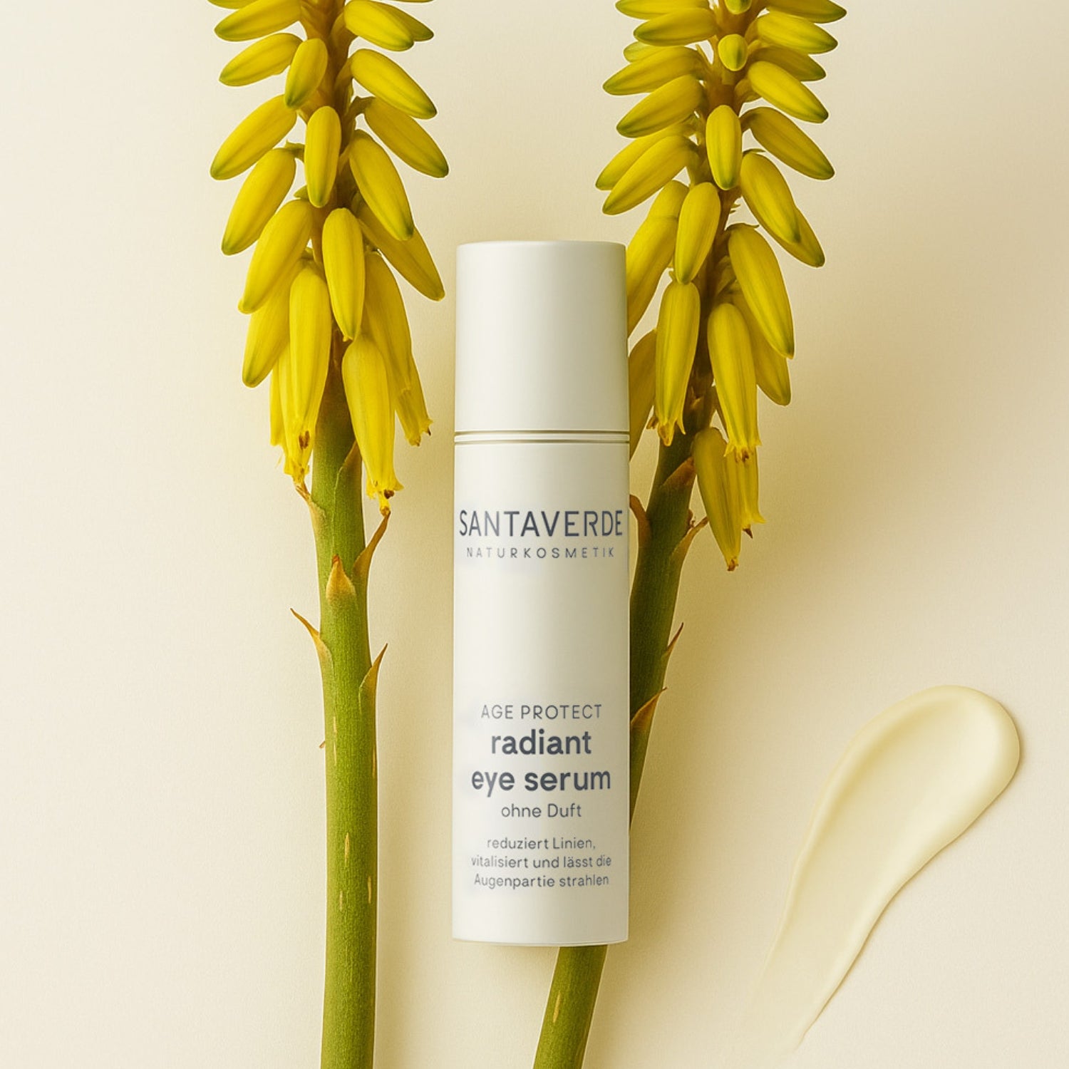 Puristisches Arrangement von zwei Aloe Vera Blüten auf hellem Hintergrund. Davor das Santaverde radiant eye serum