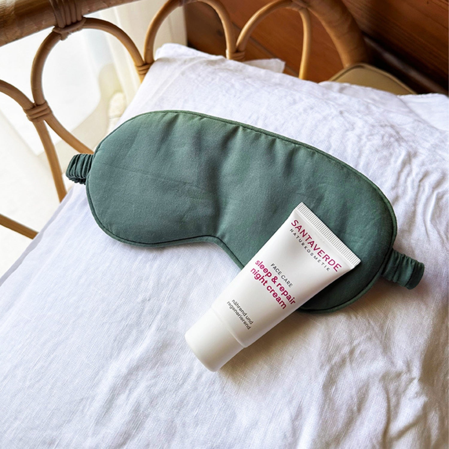 Schlafmaske und sleep & repair night cream auf einem Kissen in mediterranem Umfeld